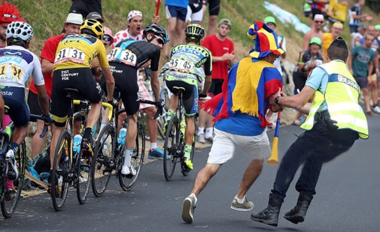 A French Gendarme restrains a fan during stage 19 of the 2015 Tour de France from Saint-Jean-de-Maurienne to La Troussuire on July 24, 2015 in La Toussuire, France.